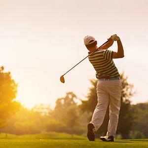 Golfer swings at a ball