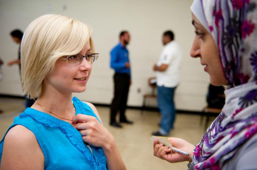 Two participants speaking together in a large auditorium. 