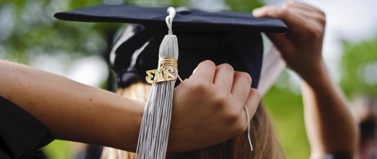 A student putting on her cap