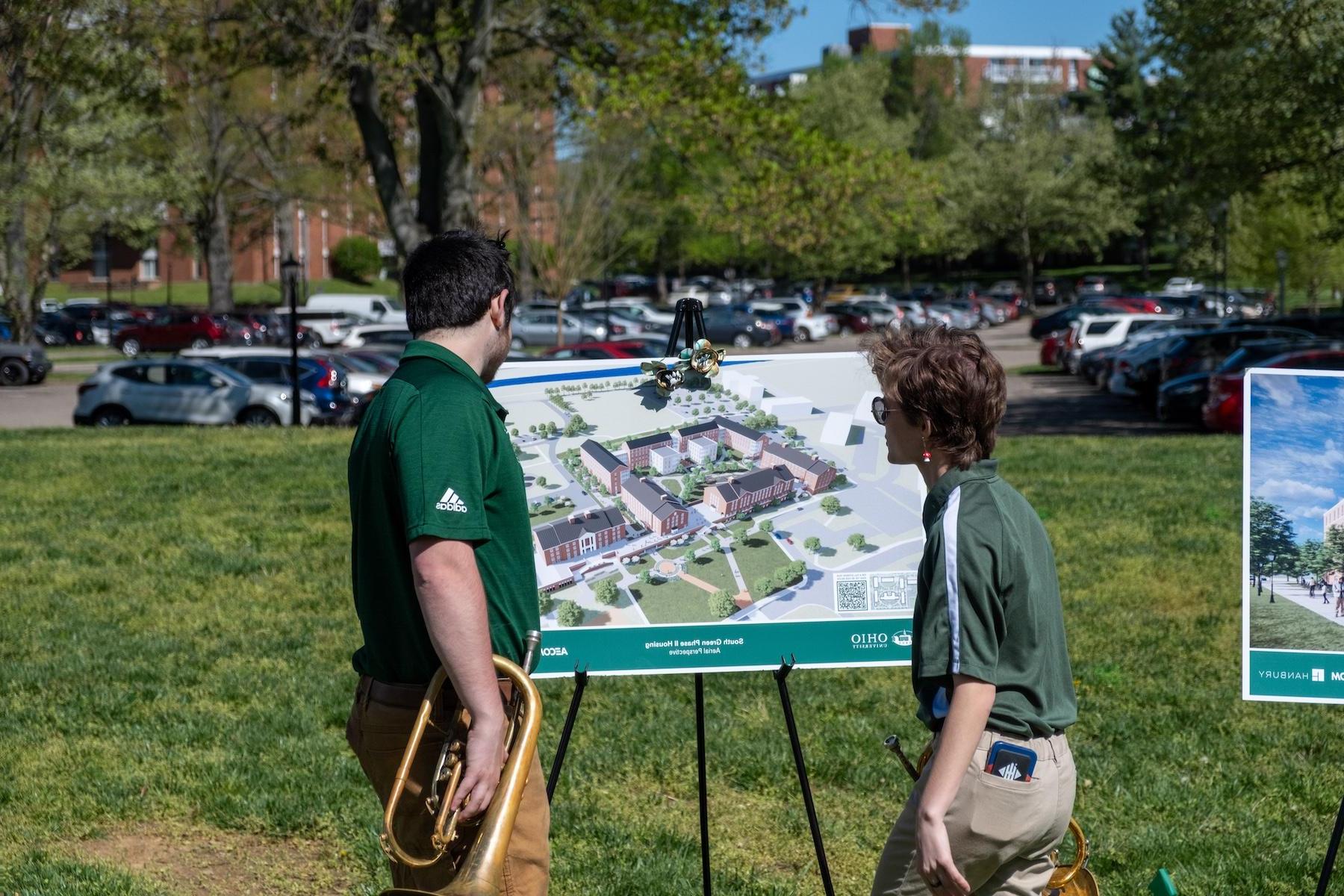 students looking at the renderings of the new residence halls