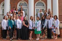 A group of nursing graduates outside a building